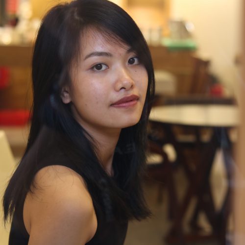 Beautiful young Vietnamese lady turning to look at the camera