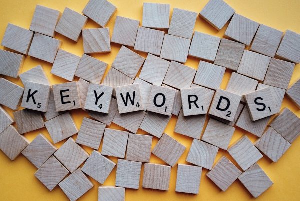 scrabble-like tiles with some turned up to spell out the word 'Keywords' for SEO